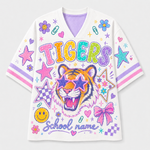 A white short-sleeve V-neck t-shirt featuring a colorful graphic design with a tiger wearing star-shaped sunglasses, the word 'TIGERS' in rainbow letters, and 'School name' script. The shirt is decorated with stars, bows, smiley faces, and pink and purple stripes on the sleeves.