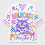 A white V-neck short-sleeve t-shirt featuring a colorful graphic of a purple wildcat wearing star-shaped sunglasses, surrounded by stars, smiley faces, bows, and the text 'WILDCATS' and 'School name'.