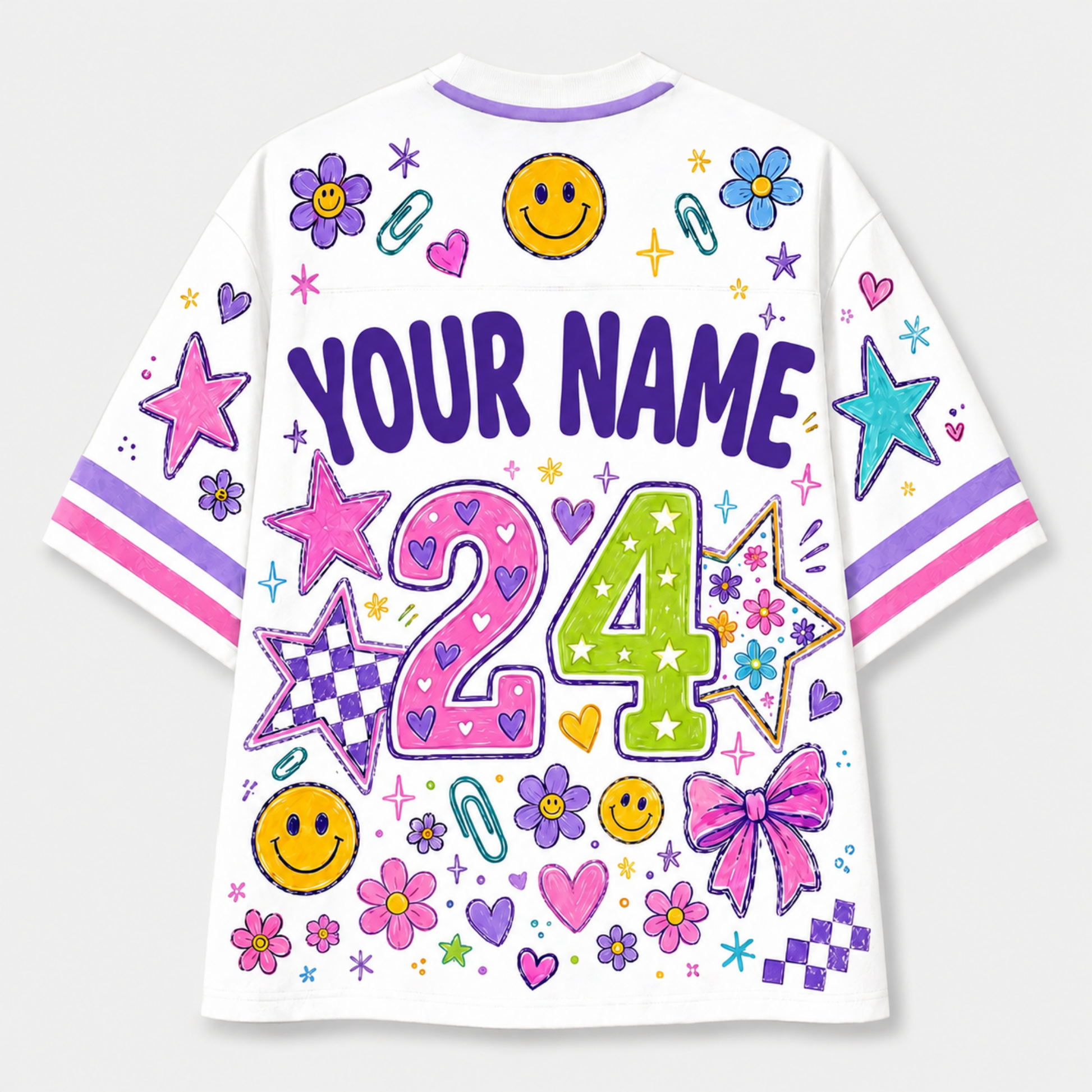 White short-sleeve t-shirt with colorful custom graphics, including 'YOUR NAME', the number '24', smiley faces, stars, flowers, and hearts, shown on a light gray background.