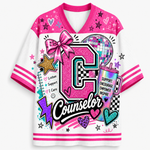 A women's V-neck athletic-style graphic top with bright pink and white color blocking, featuring a large glittery pink letter 'C' and the word 'Counselor,' plus decorative stars, hearts, a disco ball, and motivational text on a white background.
