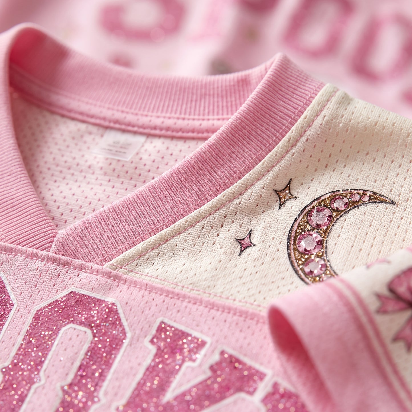 Micro view of the premium breathable bird's eye pique mesh fabric on ChaoticClub pink jersey, focusing on the pink trim and crescent moon print.