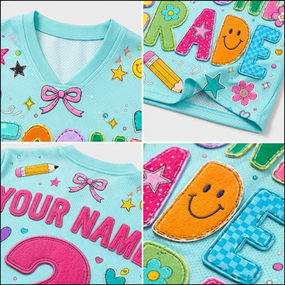 A collage showing a light blue children's shirt with colorful custom applique details, including letters, smiley faces, stars, flowers, and a bow. The shirt features a V-neck and mesh lining.