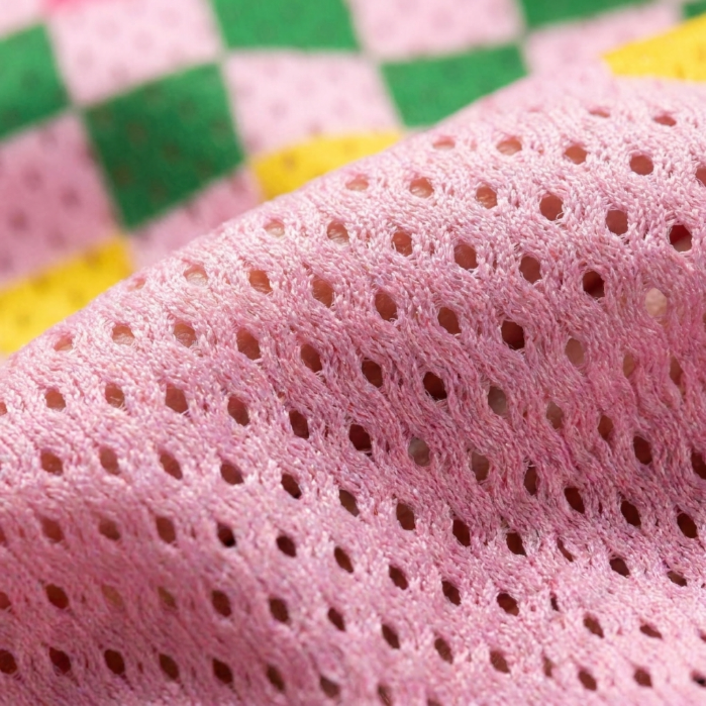 Extreme close-up of the breathable pink pro-mesh fabric used for the Goose collection, highlighting the airy texture for summer comfort.