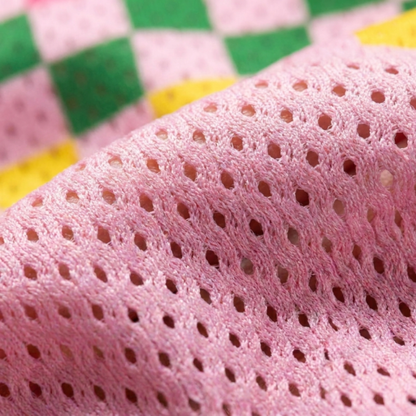 Extreme close-up of the breathable pink pro-mesh fabric used for the Goose collection, highlighting the airy texture for summer comfort.