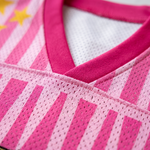 Close-up of the premium pink V-neck collar and pro-mesh fabric on a ChaoticClub summer jersey, showing the high-quality stitching, breathable mesh holes, and vibrant pink and light pink vertical stripes with yellow star details.