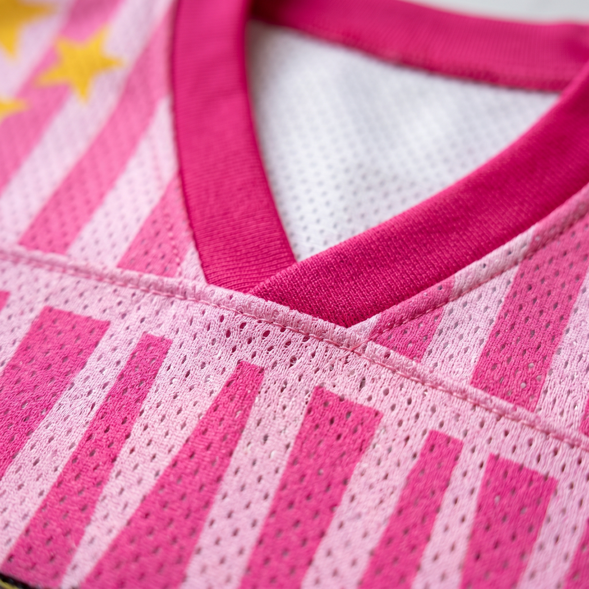 Close-up of the premium pink V-neck collar and pro-mesh fabric on a ChaoticClub summer jersey, showing the high-quality stitching, breathable mesh holes, and vibrant pink and light pink vertical stripes with yellow star details.