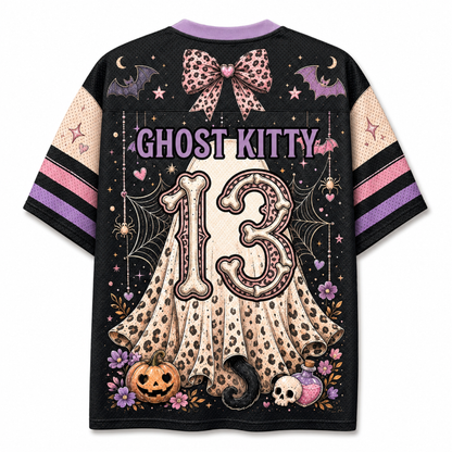 A black short-sleeve t-shirt with a detailed Halloween graphic on the back. The design features a large beige ghost with a leopard print, the number '13' in a spooky font, 'GHOST KITTY' text, pumpkins, a skull, bats, and purple accents.