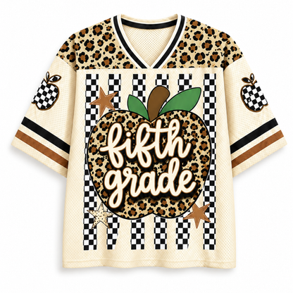 A short-sleeve mesh V-neck jersey-style shirt with a leopard-print and black-and-white checkerboard design. The front features a large apple graphic with the words 'fifth grade' in white script, green leaves, and brown stars.