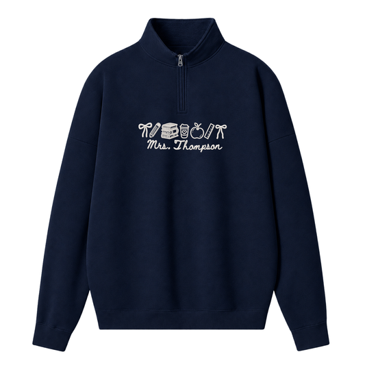 A navy blue quarter-zip sweatshirt with a white graphic print on the chest reading 'Mrs. Thompson' alongside a small illustration, shown against a plain white background.