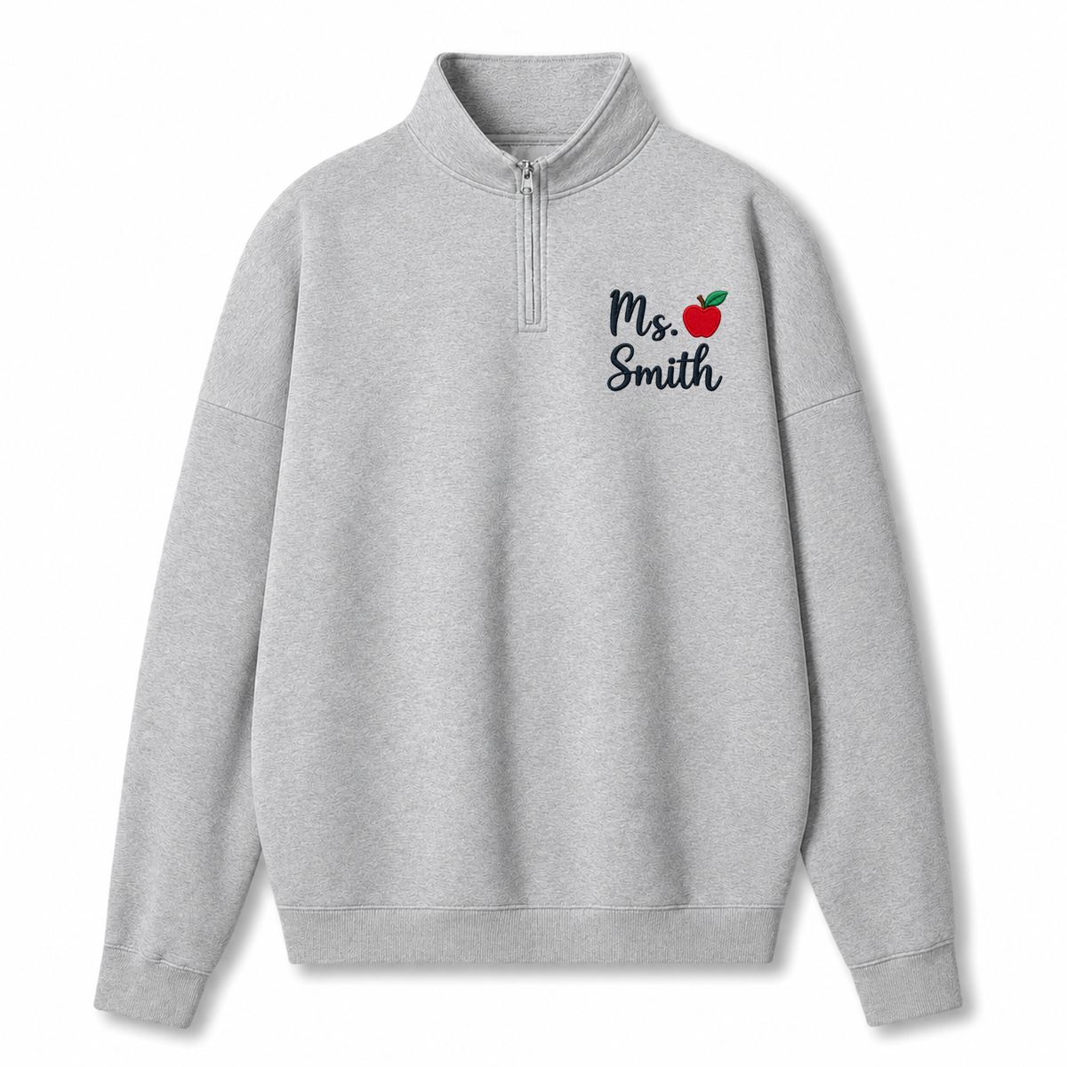 A light gray heathered quarter-zip sweatshirt with a mock neck collar, featuring the text 'Ms. Smith' and a small red apple graphic printed on the left chest, displayed on a clean white background.