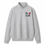 A light gray heathered quarter-zip sweatshirt with a mock neck collar, featuring the text 'Ms. Smith' and a small red apple graphic printed on the left chest, displayed on a clean white background.