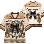 Front and back views of a Halloween-themed V-neck jersey. The jersey has a beige and brown checkerboard pattern with black lace bows, leopard-print pumpkins, spiderwebs, and bats.