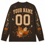 A dark brown long-sleeve t-shirt with a custom Halloween-themed graphic on the back. The design features a customizable name and number '00' in a distressed beige font, surrounded by autumn leaves, pumpkins, stars, and crescent moons in orange, beige, and brown tones.