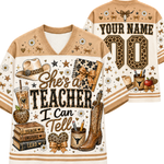 A custom-designed v-neck football-style shirt shown from both front and back. The design features a tan and cream color scheme with leopard print accents, decorated with school and teaching-themed illustrations including a cowboy hat, boots, books, an apple, and a notebook.
