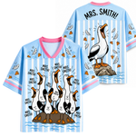 Two blue shirts with cartoon pelican design and 'Mrs. Smith!' text on a white background