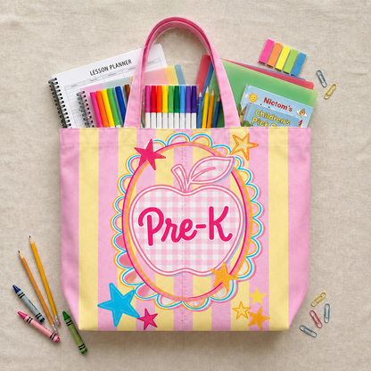 Pink and yellow tote bag with 'Pre-K' design, surrounded by school supplies on a beige background