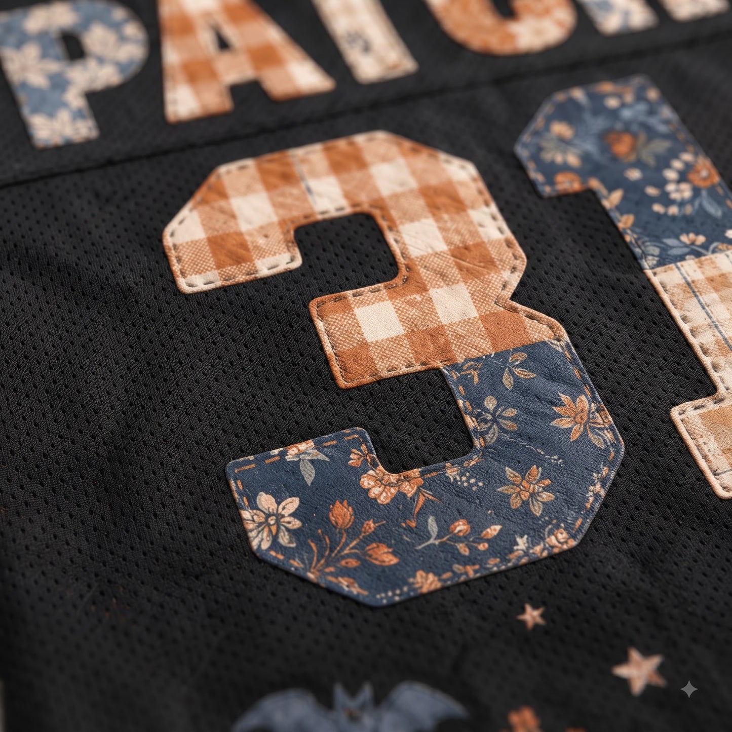 Close-up of a black mesh sports jersey with a large applique number 3 in a gingham and floral pattern, alongside partial lettering reading PATCH.